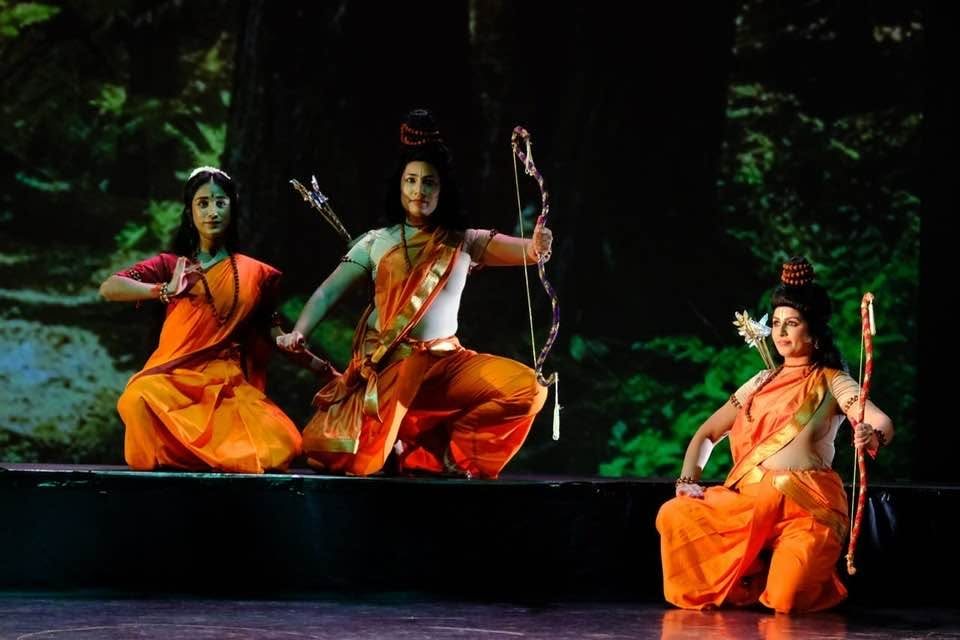 Ramayana op het podium: dansers in oranje kostuums met pijl en boog